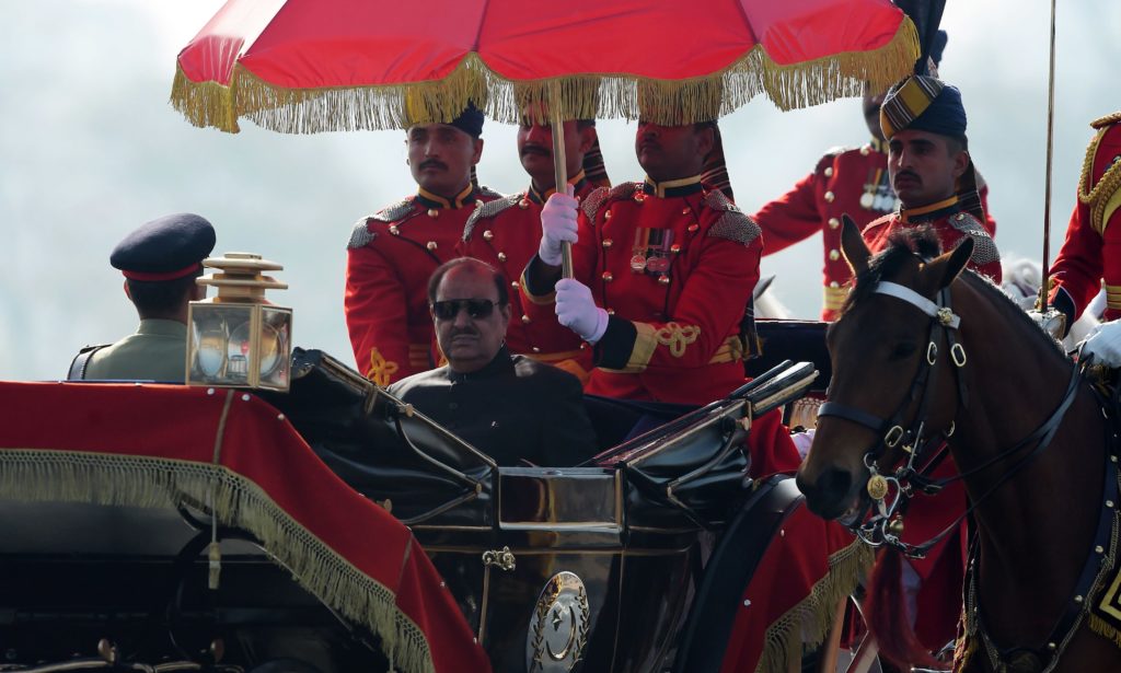 Pakistan's President Mamnoon Hussain rides a horse-drawn carriage escorted by presidential guards as he arrives at the venue for a Pakistan Day military parade in Islamabad 